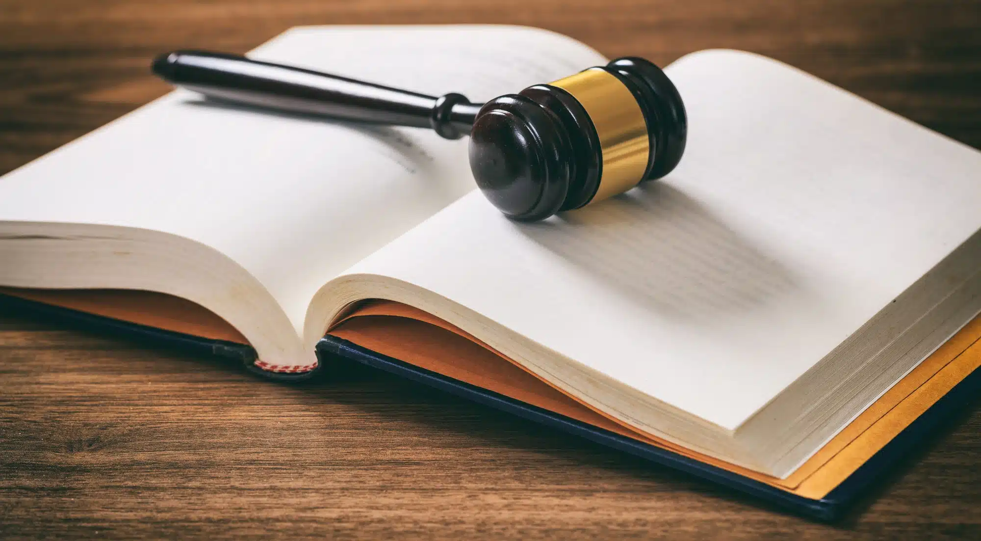 Juez o mazo de subasta en un libro abierto, escritorio de madera